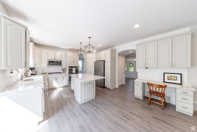 1320 E Canberra Dr, Lindon, UT 84042 - kitchen with stainless steel appliances, arched walkways, recessed lighting, white cabinetry, and light wood finished floors