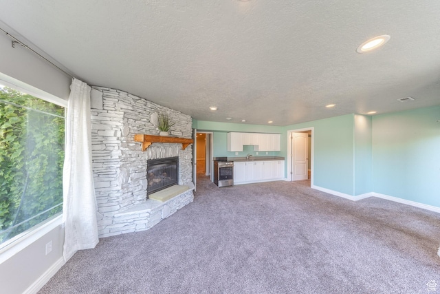 1320 E Canberra Dr, Lindon, UT 84042 - unfurnished living room with light carpet, a textured ceiling, a fireplace, and recessed lighting