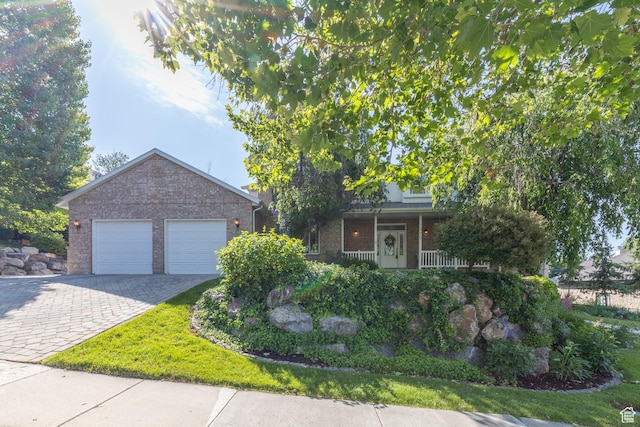 1320 E Canberra Dr, Lindon, UT 84042 - view of property hidden behind natural elements with brick siding, decorative driveway, a garage, and a porch