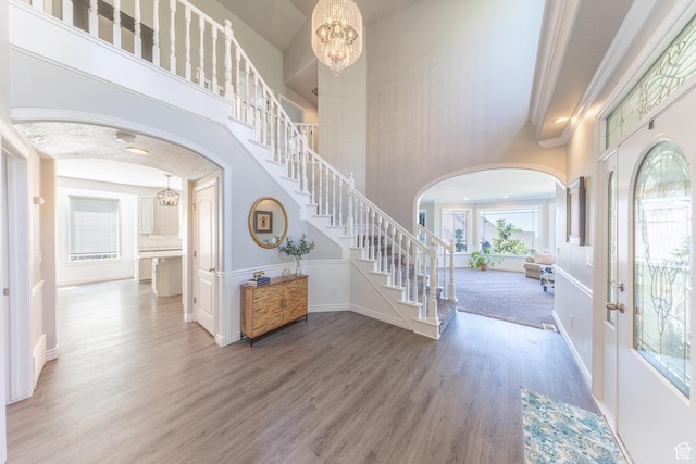 1320 E Canberra Dr, Lindon, UT 84042 - entrance foyer with arched walkways, stairs, wood finished floors, a chandelier, and a towering ceiling