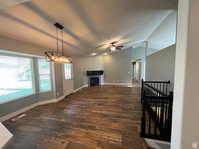 7886 S Abercrombie Ln, West Jordan, UT 84088 - unfurnished living room featuring vaulted ceiling, dark wood finished floors, a chandelier, a fireplace, and a ceiling fan