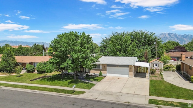 4663 S 2030 W, Taylorsville, UT 84129 - view of front of home with a front lawn, concrete driveway, a mountain view, and a garage