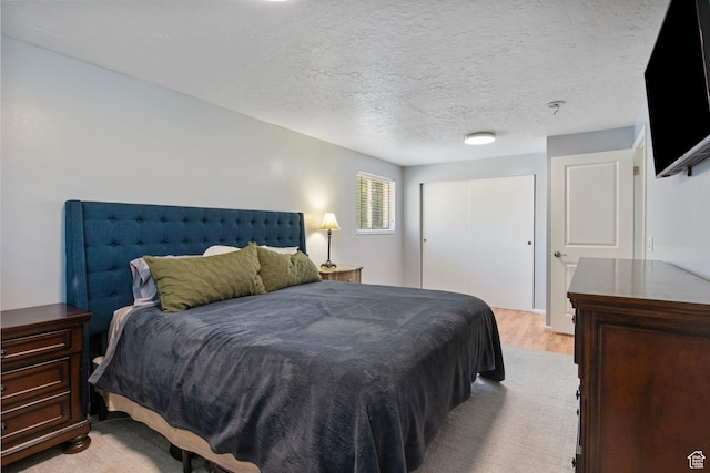 4663 S 2030 W, Taylorsville, UT 84129 - bedroom featuring light wood finished floors, a closet, and a textured ceiling