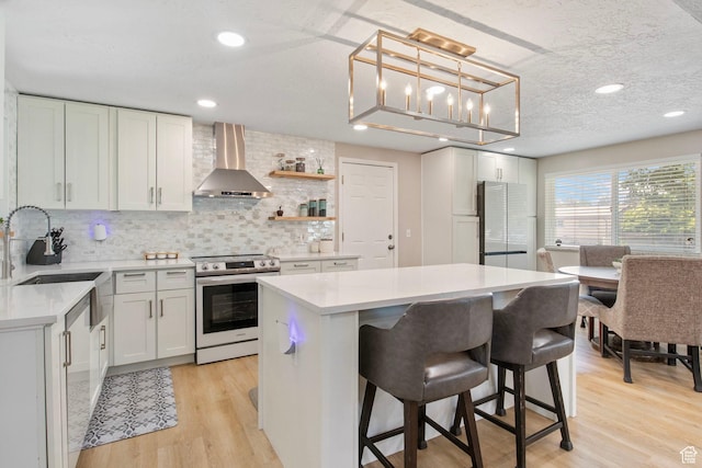 4663 S 2030 W, Taylorsville, UT 84129 - kitchen with stainless steel electric range oven, wall chimney range hood, freestanding refrigerator, a center island, and light countertops