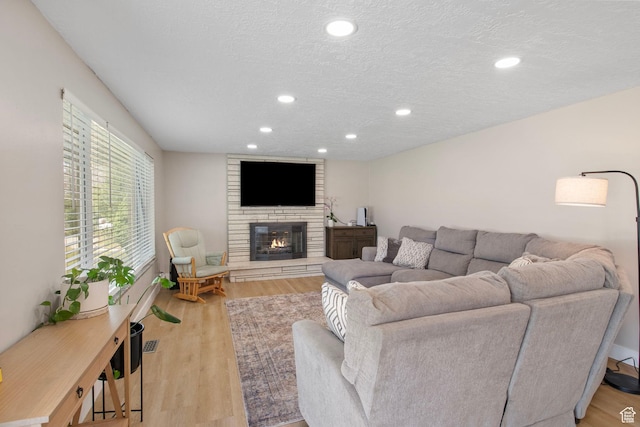 4663 S 2030 W, Taylorsville, UT 84129 - living room featuring a large fireplace, recessed lighting, wood finished floors, and a textured ceiling