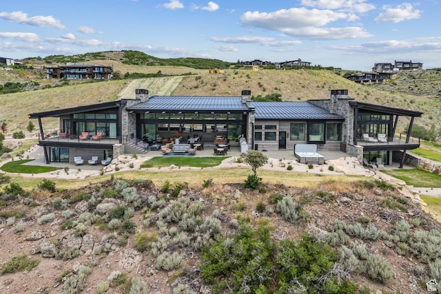 9156 N Sleeping Rock Cir, Kamas, UT 84036 - back of property featuring a chimney, a standing seam roof, stone siding, a metal roof, and a patio area