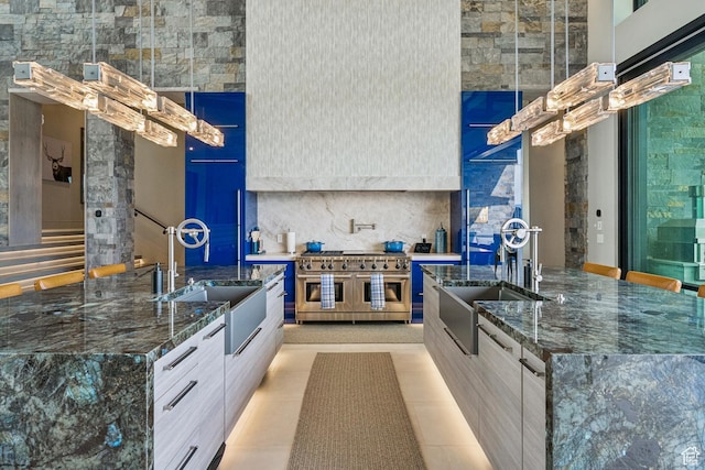 9156 N Sleeping Rock Cir, Kamas, UT 84036 - kitchen with modern cabinets, range with two ovens, an island with sink, and dark stone countertops