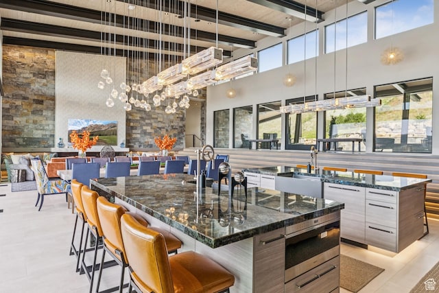 9156 N Sleeping Rock Cir, Kamas, UT 84036 - bar featuring a towering ceiling, built in microwave, beam ceiling, hanging light fixtures, and light tile patterned floors