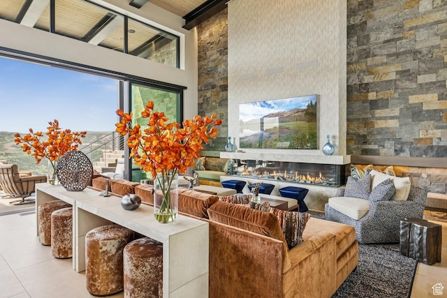 9156 N Sleeping Rock Cir, Kamas, UT 84036 - living room featuring tile patterned flooring, a high ceiling, beamed ceiling, and a glass covered fireplace