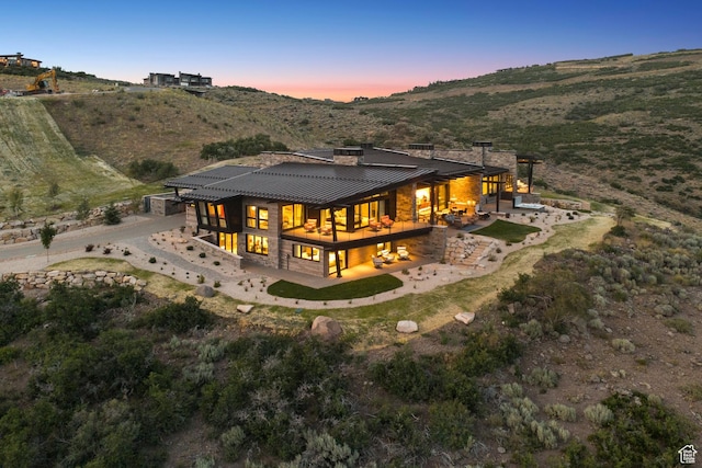 9156 N Sleeping Rock Cir, Kamas, UT 84036 - back of property at dusk featuring a patio area, a standing seam roof, a metal roof, and a mountain view