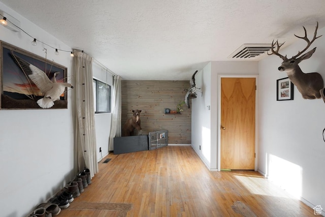 961 Hillview Rd, Brigham City, UT 84302 - foyer with wood walls, light wood-style floors, a textured ceiling, and an accent wall