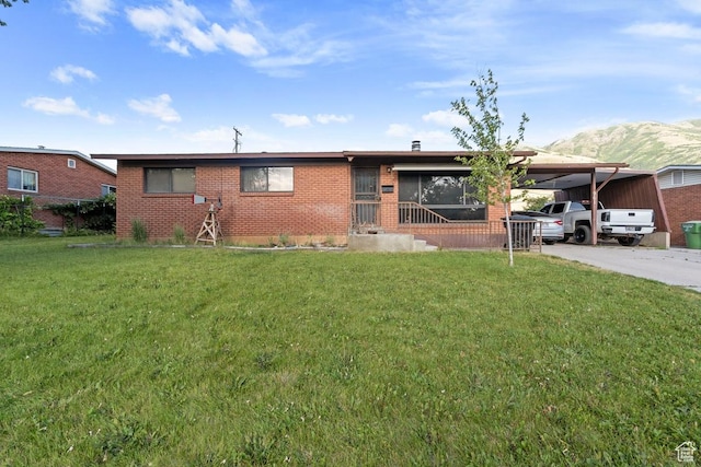 961 Hillview Rd, Brigham City, UT 84302 - view of front of home with brick siding, an attached carport, a front yard, a mountain view, and driveway