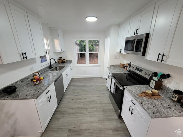 448 N 900 W, Salt Lake City, UT 84116 - kitchen featuring stainless steel appliances, light wood-style floors, white cabinets, and light stone counters