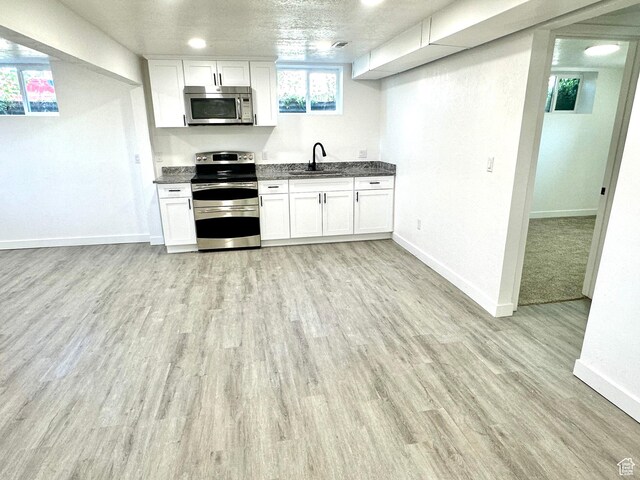 448 N 900 W, Salt Lake City, UT 84116 - kitchen featuring appliances with stainless steel finishes, light wood-style floors, white cabinets, and dark stone counters