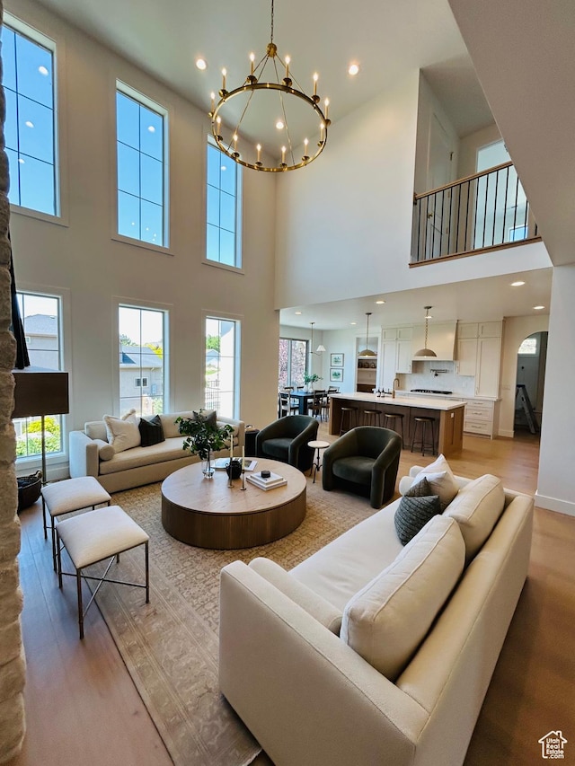 3868 N 475 E, North Ogden, UT 84414 - living area featuring a high ceiling, light wood finished floors, healthy amount of natural light, a chandelier, and arched walkways