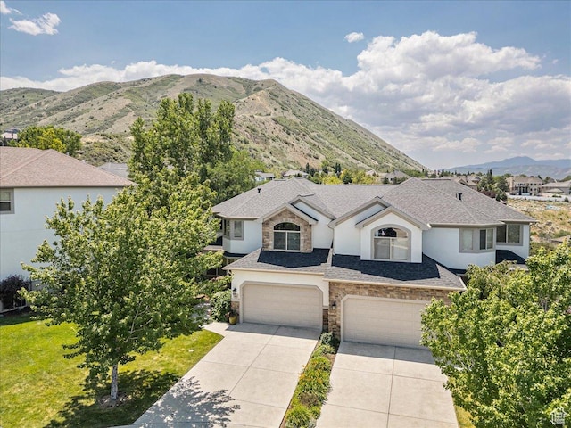 14618 S Gallatin Ln E, Draper, UT 84020 - view of front facade featuring stone siding, a mountain view, driveway, a garage, and stucco siding