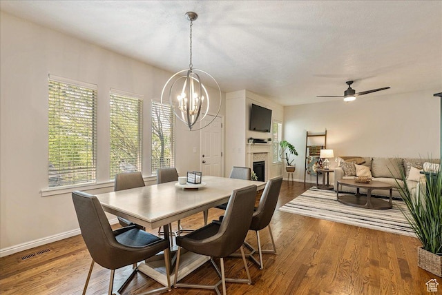 14618 S Gallatin Ln E, Draper, UT 84020 - dining space featuring a chandelier, healthy amount of natural light, a glass covered fireplace, and wood finished floors