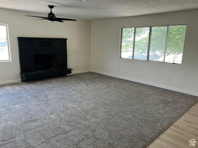 48 N Village Way, Washington, UT 84780 - unfurnished living room with ceiling fan, a textured ceiling, a fireplace, and wood finished floors