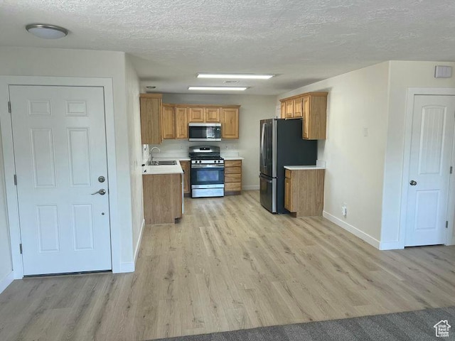 48 N Village Way, Washington, UT 84780 - kitchen featuring stainless steel appliances, light wood finished floors, light countertops, brown cabinetry, and a textured ceiling