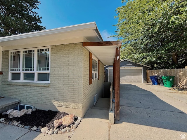 2057 E Castle Hill Ave, Cottonwood Heights, UT 84121 - view of side of home featuring brick siding, driveway, a garage, and an outdoor structure