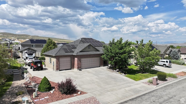 2618 W Mountain Rd, Tremonton, UT 84337 - view of front of home with roof mounted solar panels, driveway, a residential view, and a shingled roof