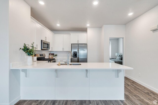 1052 W Azul Meadows Way S, Bluffdale, UT 84065 - kitchen featuring stainless steel appliances, a peninsula, light countertops, a kitchen bar, and recessed lighting