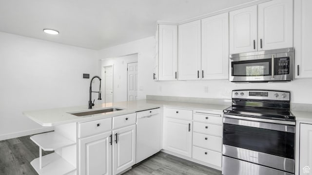 6568 S 5180 W, West Jordan, UT 84081 - kitchen featuring appliances with stainless steel finishes, a peninsula, light wood-type flooring, white cabinetry, and light countertops