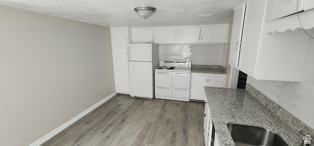 1444 S Beacon Dr E, Salt Lake City, UT 84108 - kitchen with white appliances, decorative backsplash, wood finished floors, a textured ceiling, and white cabinets