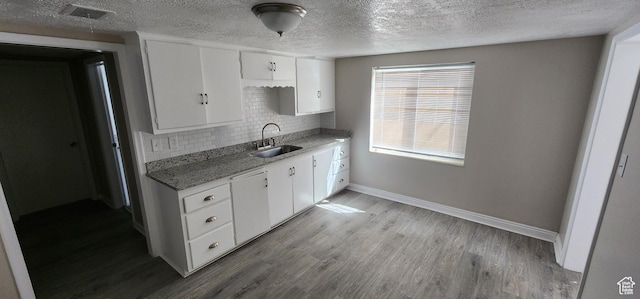 1444 S Beacon Dr E, Salt Lake City, UT 84108 - kitchen with tasteful backsplash, white cabinetry, light wood-style floors, a textured ceiling, and light stone countertops