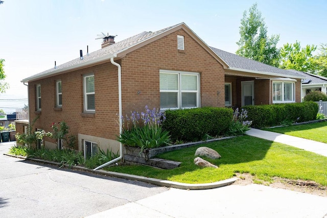 1444 S Beacon Dr E, Salt Lake City, UT 84108 - ranch-style home with brick siding, a front yard, a chimney, and a shingled roof