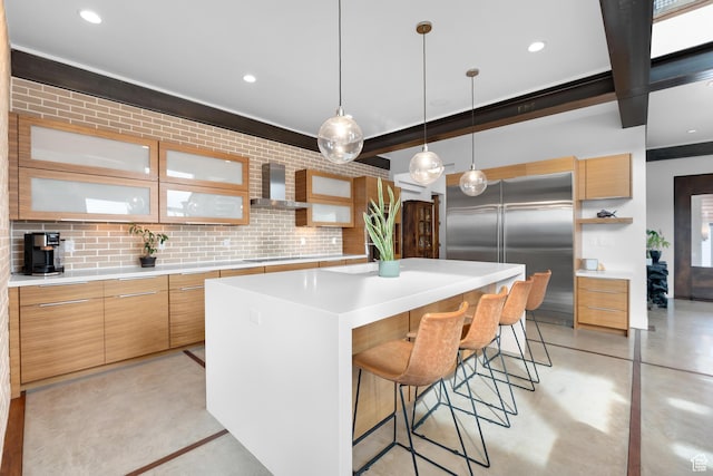 4601 N Toscana Hills Dr, Lehi, UT 84043 - kitchen with wall chimney range hood, built in fridge, a center island, concrete flooring, and a breakfast bar