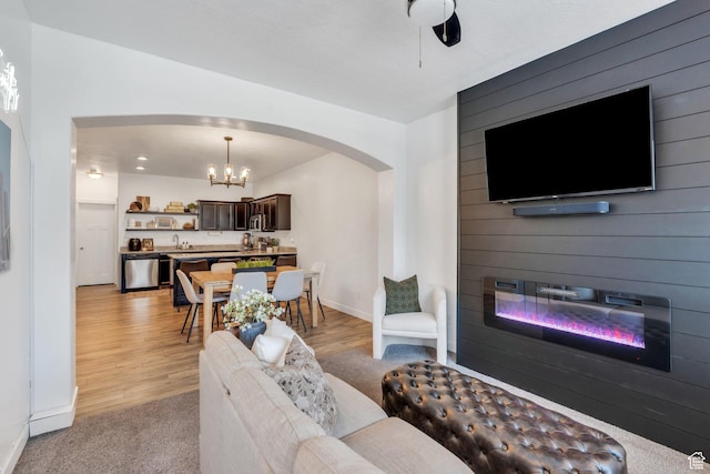330 N 680 E Unit 330, Vineyard, UT 84059 - living area featuring arched walkways, a large fireplace, a chandelier, and light wood-type flooring