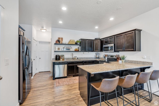 330 N 680 E Unit 330, Vineyard, UT 84059 - kitchen with stainless steel appliances, a peninsula, open shelves, light wood-style flooring, and recessed lighting