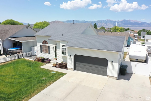 1018 S 810 W, Tooele, UT 84074 - view of front of house with a garage, concrete driveway, a mountain view, a gate, and a residential view
