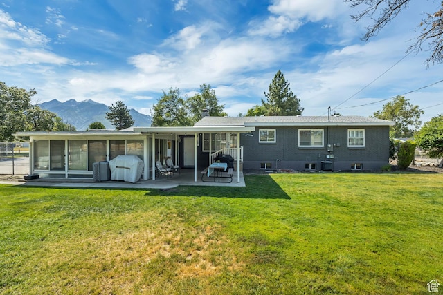 1895 E Brookhill Dr, Cottonwood Heights, UT 84121 - rear view of house with a sunroom, a patio area, a yard, and a mountain view