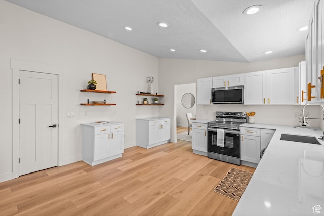 11362 S Mariposa Way E, Sandy, UT 84094 - kitchen with stainless steel appliances, open shelves, vaulted ceiling, light wood-style flooring, and white cabinetry