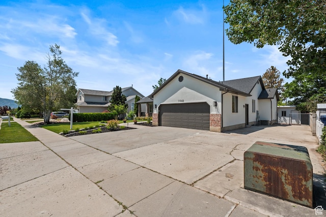 11362 S Mariposa Way E, Sandy, UT 84094 - view of front of home featuring a garage, stucco siding, driveway, and brick siding
