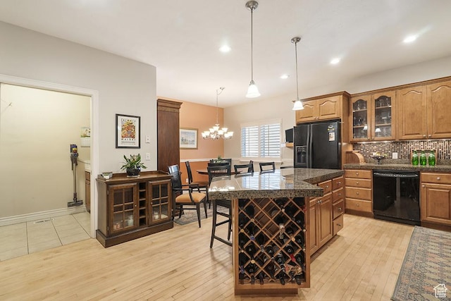 4470 S Snowmass Ct, Millcreek, UT 84124 - kitchen featuring black appliances, glass insert cabinets, dark countertops, decorative backsplash, and a breakfast bar area