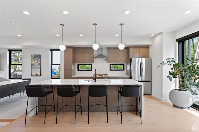 537 S 500 E Unit 106, Salt Lake City, UT 84102 - kitchen with freestanding refrigerator, wall chimney range hood, recessed lighting, light countertops, and a spacious island