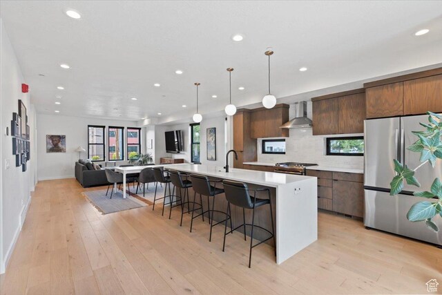 537 S 500 E Unit 106, Salt Lake City, UT 84102 - kitchen with freestanding refrigerator, wall chimney range hood, modern cabinets, light countertops, and recessed lighting