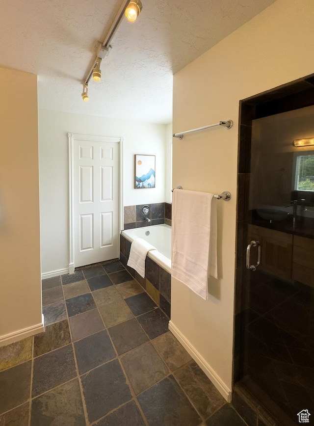 841 E 8600 S, Sandy, UT 84094 - full bath featuring a bath, a textured ceiling, a shower with door, and stone finish flooring