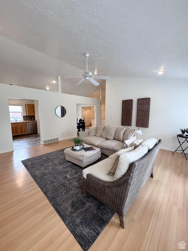 841 E 8600 S, Sandy, UT 84094 - living room featuring a textured ceiling, lofted ceiling, light wood-style floors, and a ceiling fan