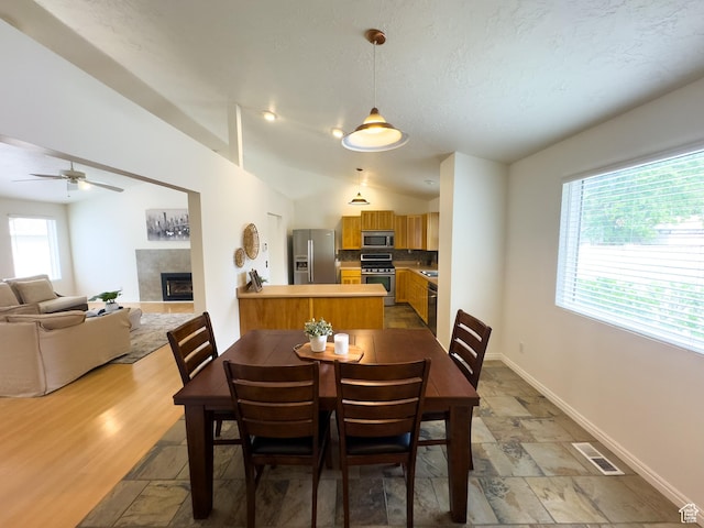 841 E 8600 S, Sandy, UT 84094 - dining space with stone tile floors, a tile fireplace, a ceiling fan, and lofted ceiling