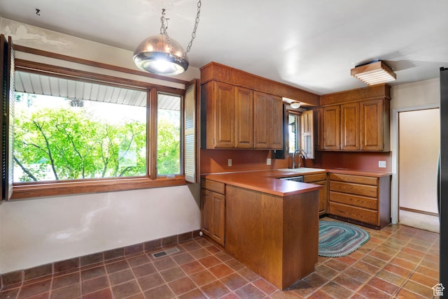 451 S 800 E, Orem, UT 84097 - kitchen featuring a peninsula, brown cabinetry, and light countertops