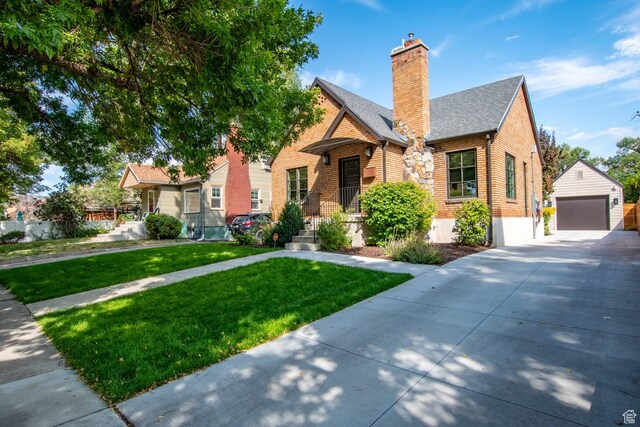 1127 S Denver St S, Salt Lake City, UT 84111 - view of front of property featuring an outdoor structure, a detached garage, a front yard, a chimney, and brick siding