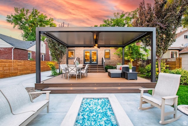 1127 S Denver St S, Salt Lake City, UT 84111 - back of property at dusk featuring french doors, brick siding, a deck, an outdoor hangout area, and a patio