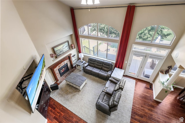 14346 S Fort Duchesne Cv, Herriman, UT 84096 - living area with a high ceiling, wood finished floors, and a glass covered fireplace