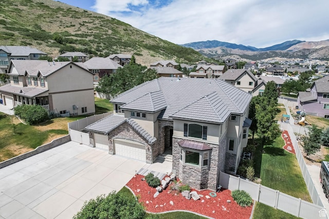 14346 S Fort Duchesne Cv, Herriman, UT 84096 - view of front of home featuring stone siding, a residential view, a garage, and concrete driveway