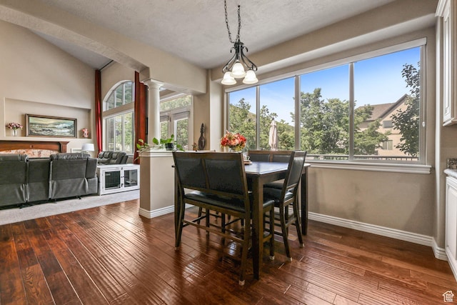 14346 S Fort Duchesne Cv, Herriman, UT 84096 - dining room with decorative columns, dark wood-style floors, and a textured ceiling
