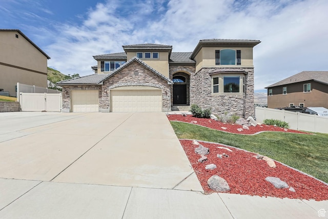 14346 S Fort Duchesne Cv, Herriman, UT 84096 - view of front facade with stone siding, stucco siding, driveway, a garage, and a tiled roof